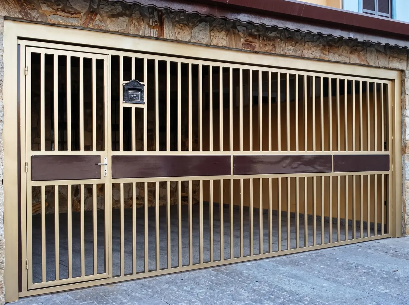 Portão de correr com barras verticais, instalado na entrada de uma garagem